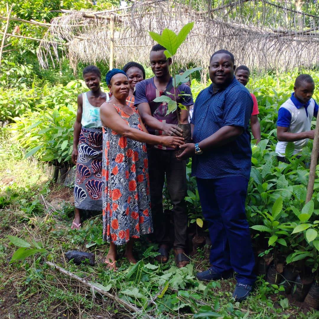 Farmers hold cocoa trees donated via Association Morija